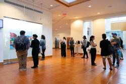 Visitors in the theater lobby stand and mingle with one another.